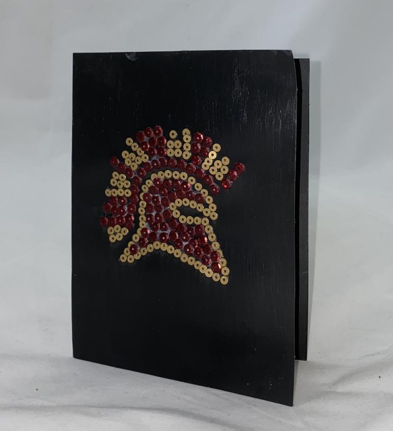 Black notebook with a decorative Spartan helmet design on the cover.
