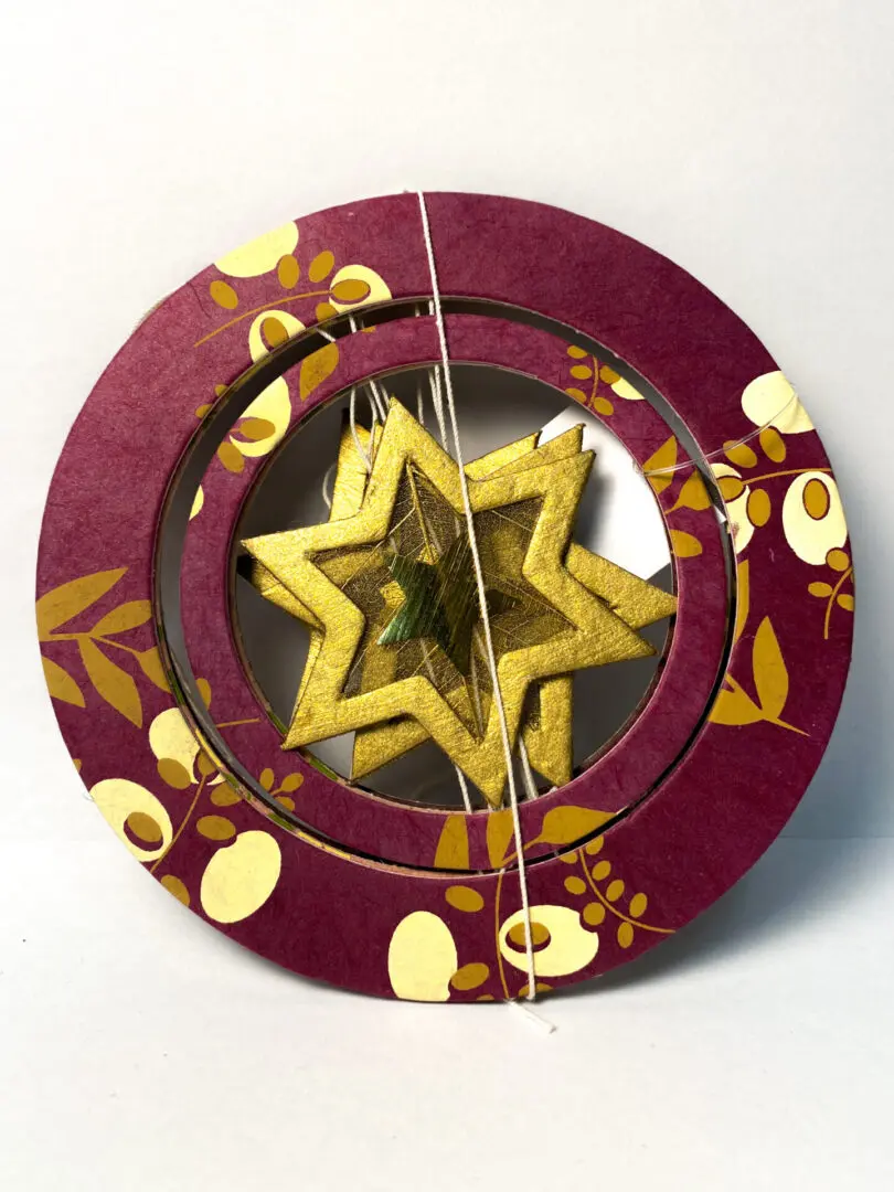 A Maroon Color Disc With a Gold Star Inside