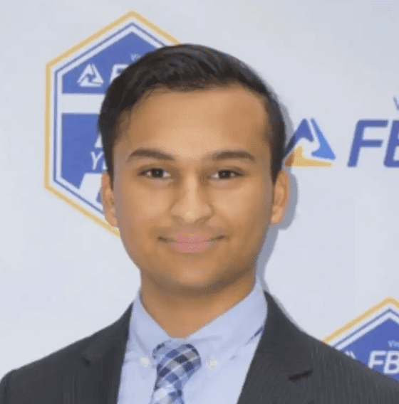 Professional young man in a suit and tie smiling at the camera.