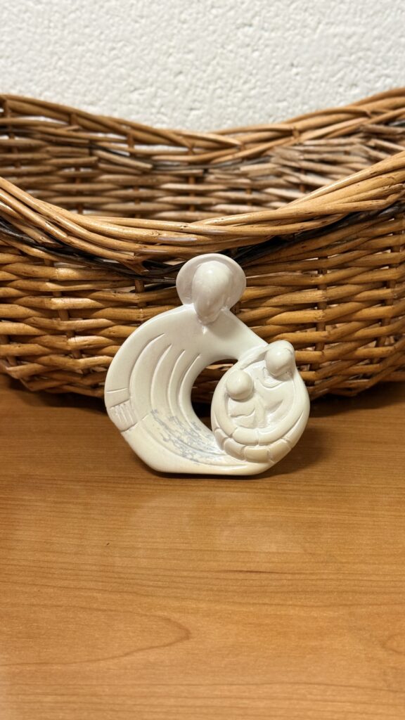 White ceramic sculpture with woven basket backdrop.