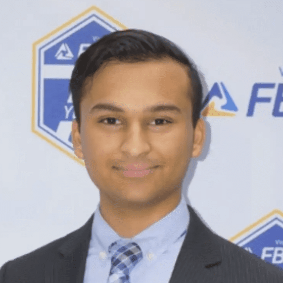 Professional young man in a suit and tie smiling at the camera.