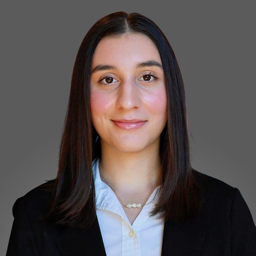 Professional portrait of a young woman with long dark hair and a blazer.